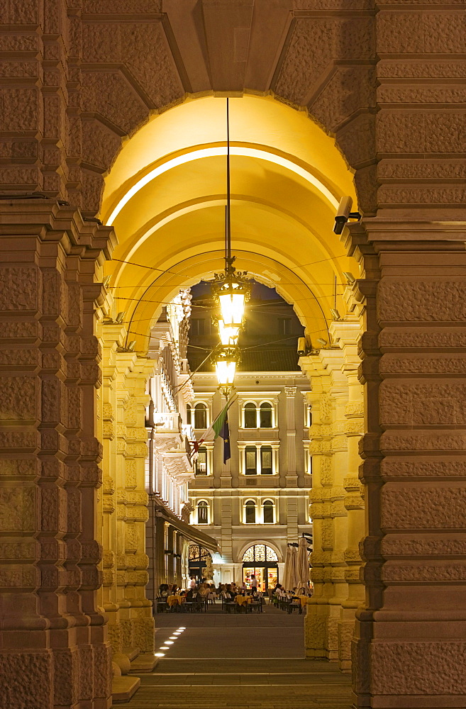 View through the arcades of the Palazzo del Governo onto the the terrace of the Cafe degli Specchi, Trieste, Friuli-Venezia Giulia, Upper Italy, Italy