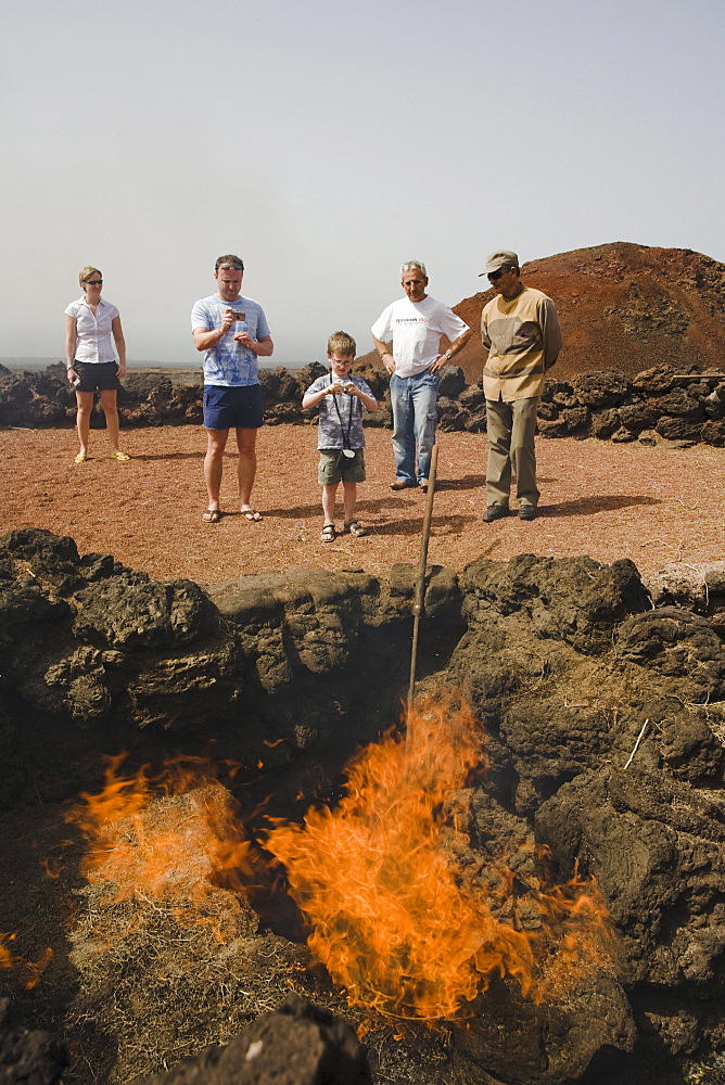 Demonstration of fire by volcanic heat with brushwood, Parque Nacional de Tiimanfaya, Montanas del Fuego, park ranger, family, UNESCO Biosphere Reserve, Lanzarote, Canary Islands, Spain, Europe