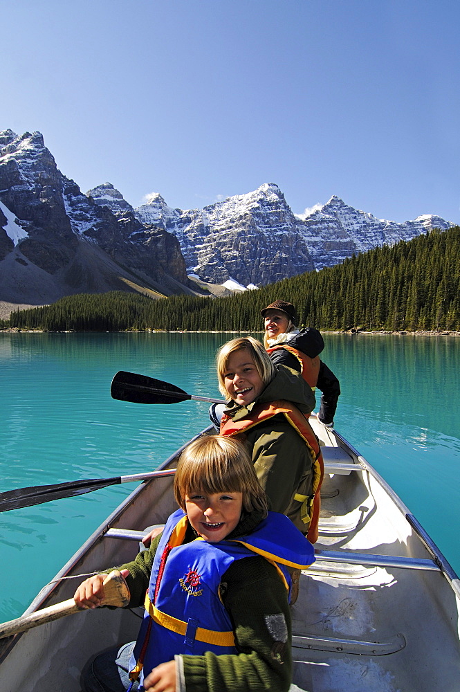 Family in paddle boat, Moraine Lake, Banff National Park, Alberta, Canada