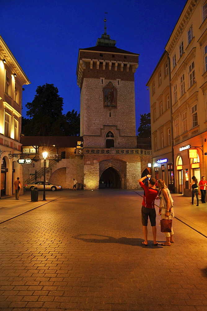 Tourists taking picture of the Ccity gate in the evening, fortress Barbakan, Krakow, Poland, Europe