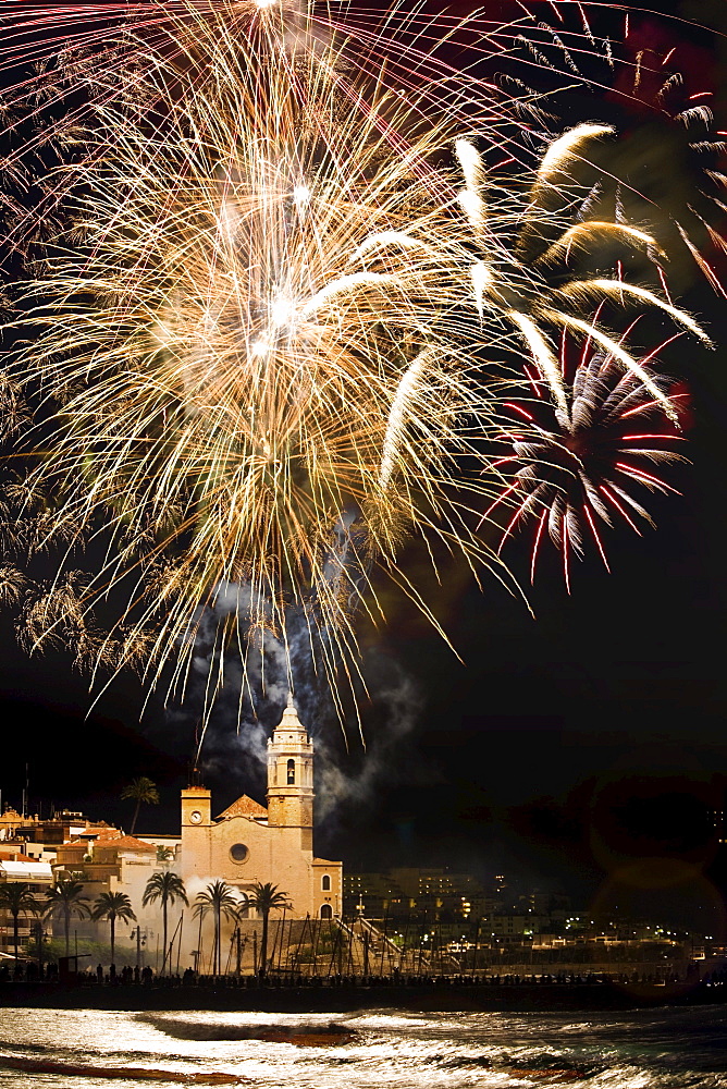 Firework display over Sitges Cathedral La Punta at night, Festival of Santa Tecla, Sitges, Catalonia, Spain, Europe