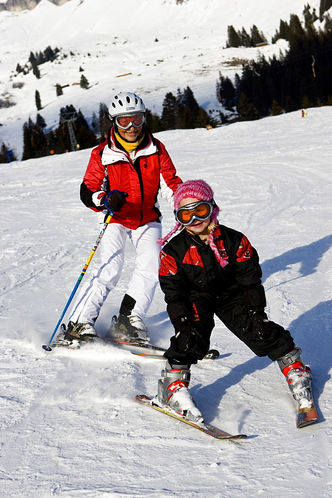 A little girl and her grandmother skiing at Flims, Graubuenden, Switzerland