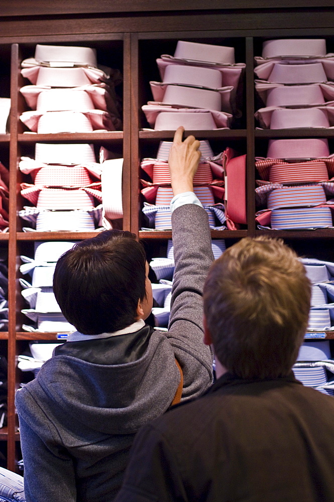 A couple in a mens clothes shop looking at shirts, Ingolstadt, Bavaria, Germany