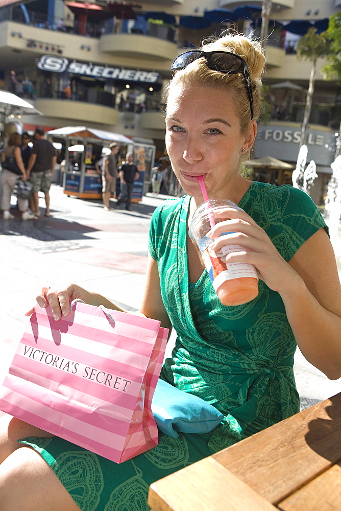 Woman enjoying a drink in a cafe after a shopping tour in the Kodak theatre complex, Graumans Chinese Theater, Hollywood, Los Angeles, California, USA