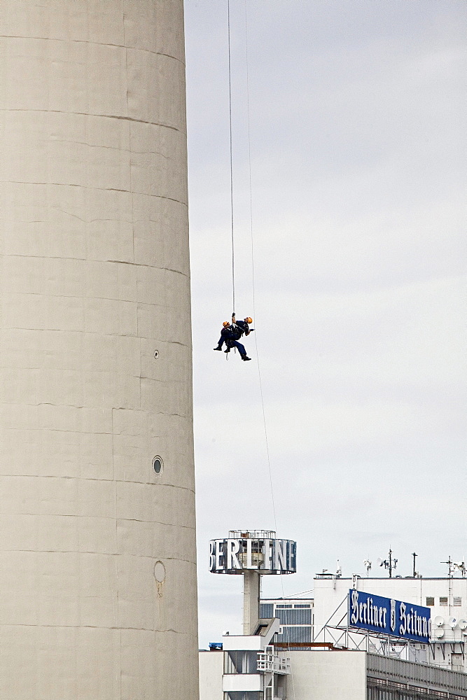 Two industrial climbers abseiling on the tower of Berlin's Television Tower, Alex, Berlin, Germany