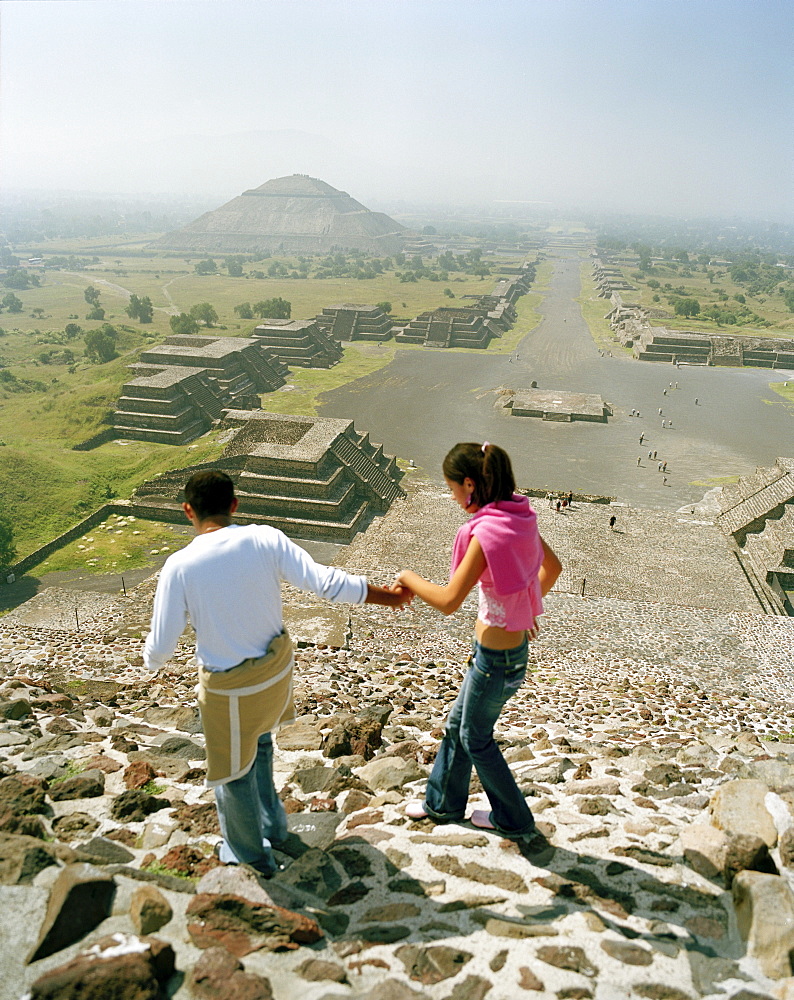 Young couple on top of moon pyramid, view at street of the dead, temple complex Teotihuacan, Mexico, America