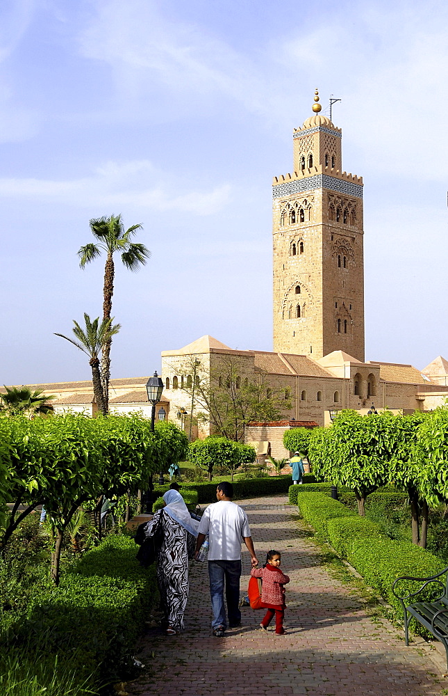 Family at a park in front of the Minaret of the Koutoubia Mosque, Marrakesh, South Morocco, Morocco, Africa