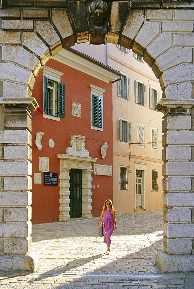 A woman and venetian Balbi gate at the Old Town of Rovinj, Croatian Adriatic Sea, Istria, Croatia, Europe