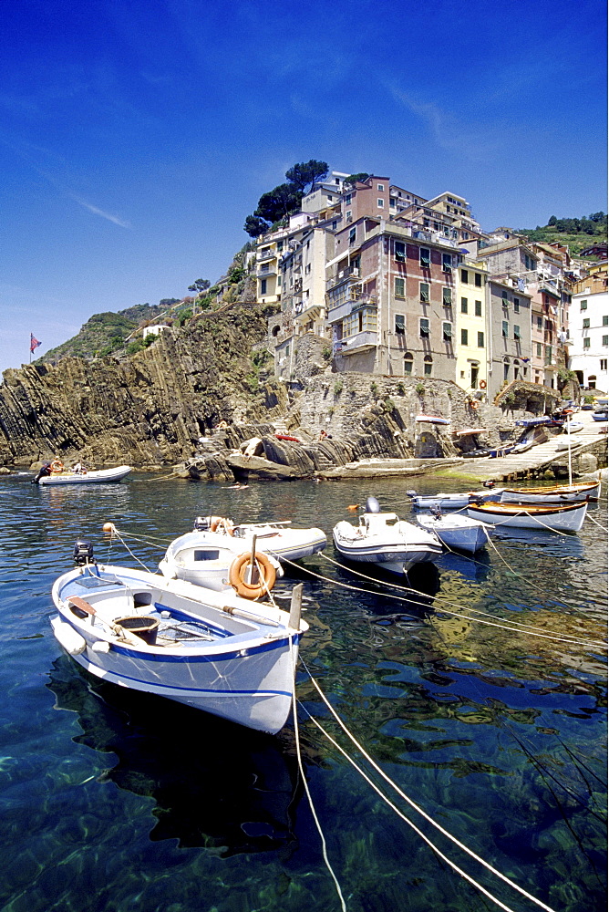 Fishing boats at harbour under blue sky, Riomaggiore, Cinque Terre, Liguria, Italian Riviera, Italy, Europe