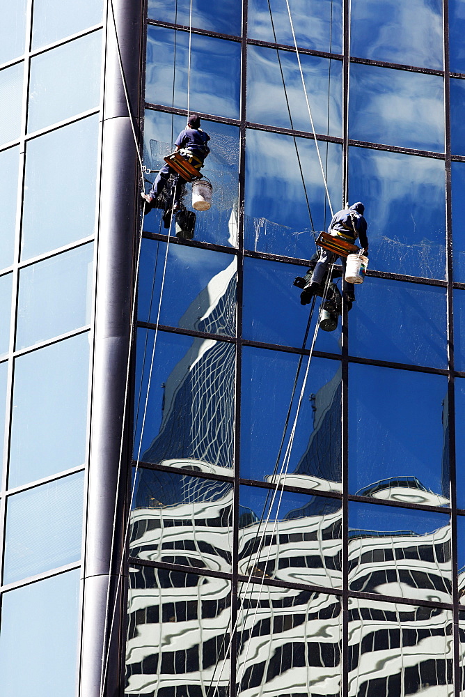 Window cleaner cleaning the outside of a skyscaper building, Chicago, Illinois, USA