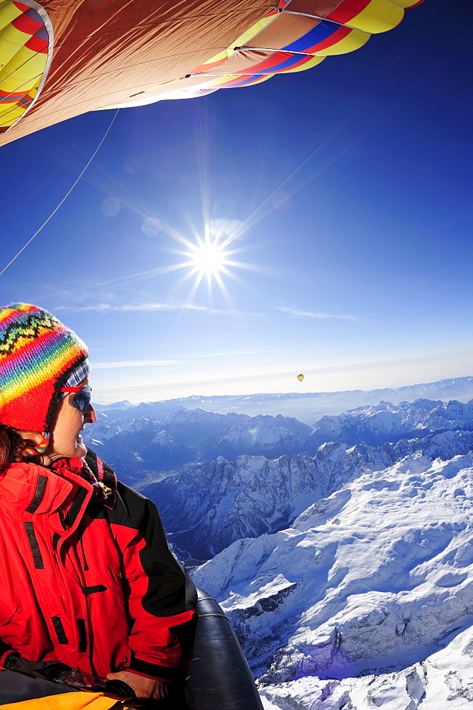 Woman in hot-air balloon enjoying view to Pala range in winter, aerial photo, Pala range, Dolomites, Venetia, Italy, Europe