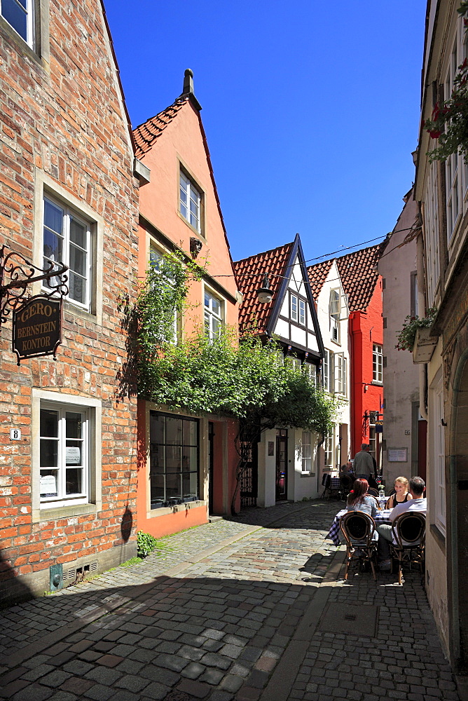 People at street cafe and historical houses at Schnoor quarter, Hanseatic City of Bremen, Germany, Europe