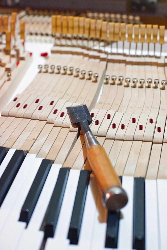 Tool on piano keys, piano making, Bavaria, Germany