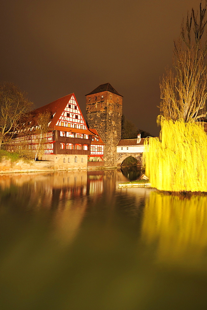 Illuminated Weinstadel, wine store and water tower and the river Pegnitz at night, Nuremberg, Bavaria, Germany