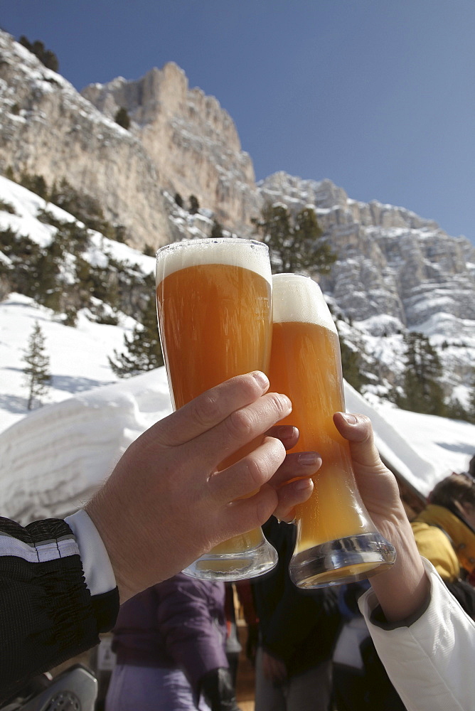 Two persons clinking wheat beer glasses, Alta Badia, Dolomites, Trentino-Alto Adige/Suedtirol, Italy