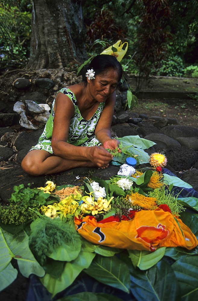 A native woman binding bouquets of flowers in the village of Omoa, island of Nuku Hiva, French Polynesia