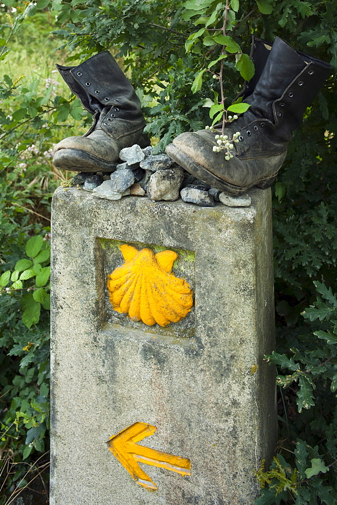 Old boots on signpost with scallop, Province of La Coruna, Galicia, Northern Spain, Spain, Europe