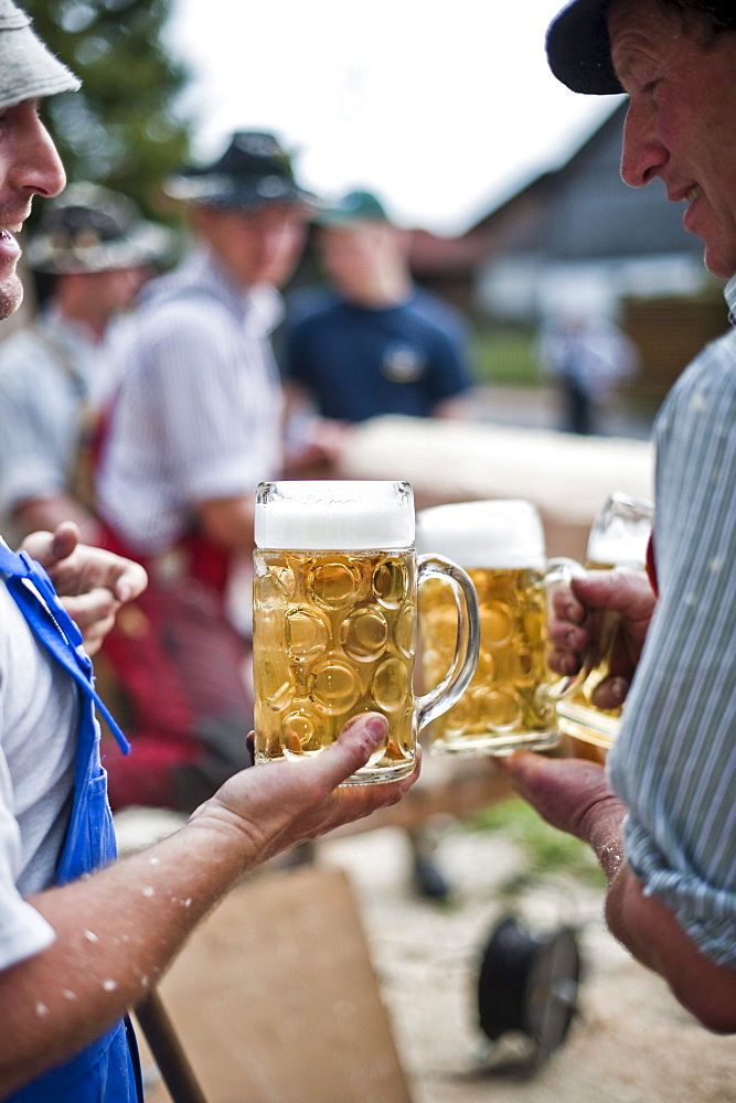 Two men holding beer mugs, Erection of Maypole, Sindelsdorf, Weilheim-Schongau, Bavarian Oberland, Upper Bavaria, Bavaria, Germany