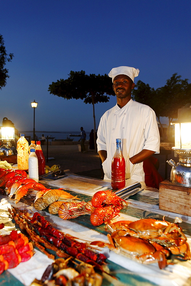 Monger at a stand, night market at Forodhani Gardens, Stonetown, Zanzibar City, Zanzibar, Tanzania, Africa