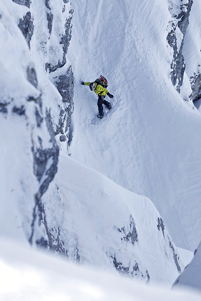 Snowboarder in deep snow between rocks, Oberjoch, Bad Hindelang, Bavaria, Germany