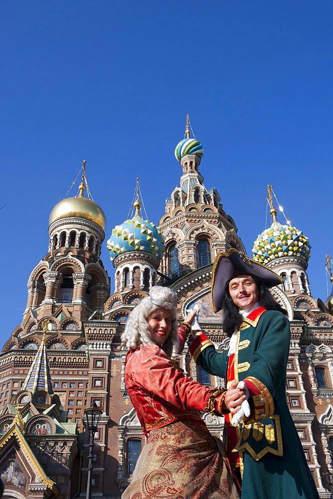 Couple in historic costumes pose as Empress and Tsar in front of Church of the Savior on Spilled Blood, Church of the Resurrection, St. Petersburg, Russia