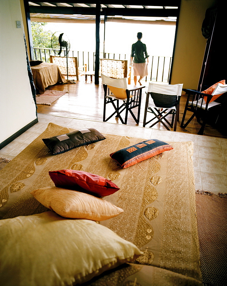 Woman in Superior Room Chalet, Mango Lodge, view over Anse Volbert, Bahia Ste. Anne, Praslin, Republic of Seychelles, Indian Ocean