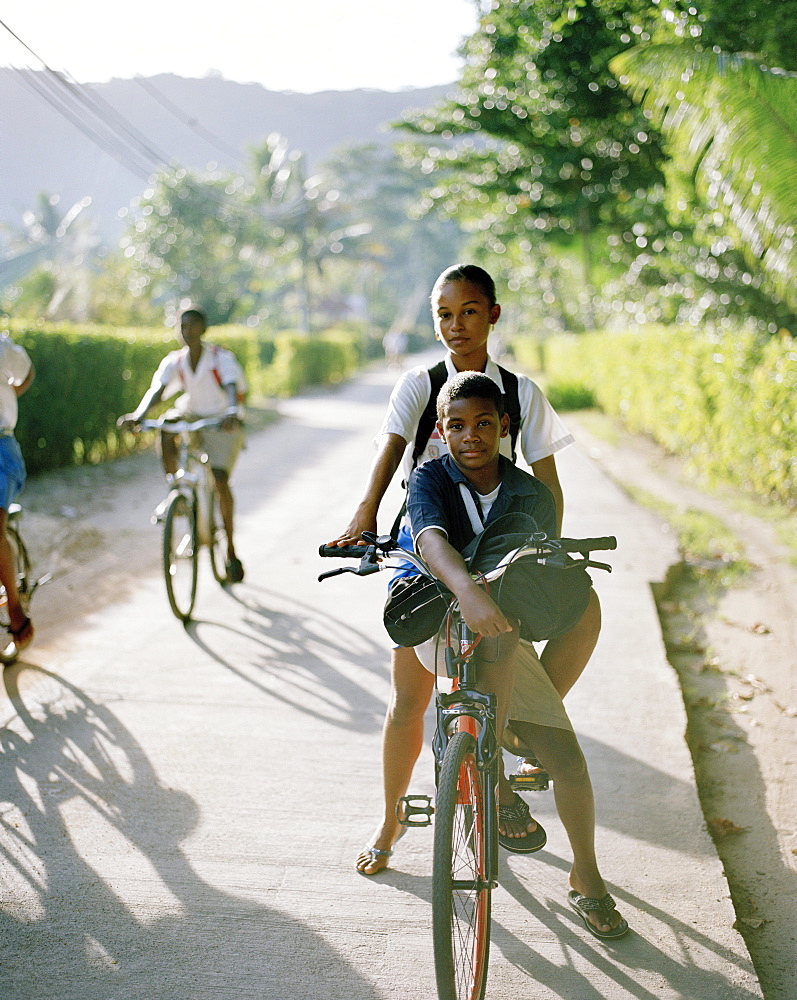 Kids riding their bikes to school, Anse La Reunion, La Digue, La Digue and Inner Islands, Republic of Seychelles, Indian Ocean