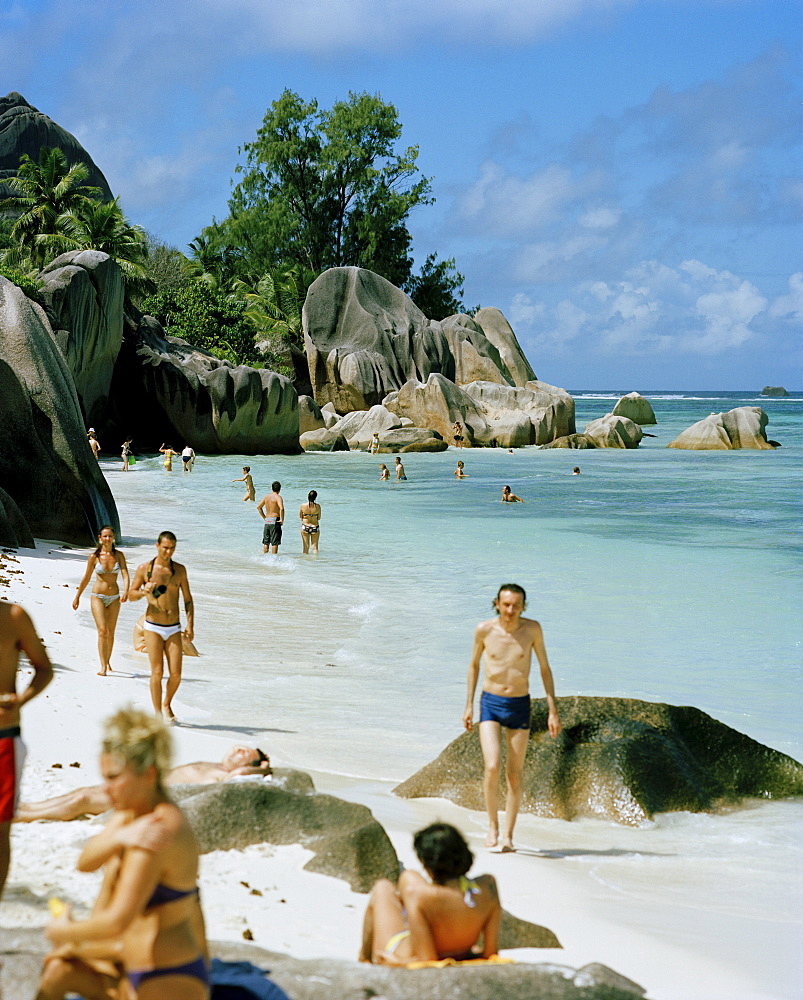 Tourists on worlds most famous beach Anse Source d'Argent with its granitic rocks, south western La Digue, La Digue and Inner Islands, Republic of Seychelles, Indian Ocean