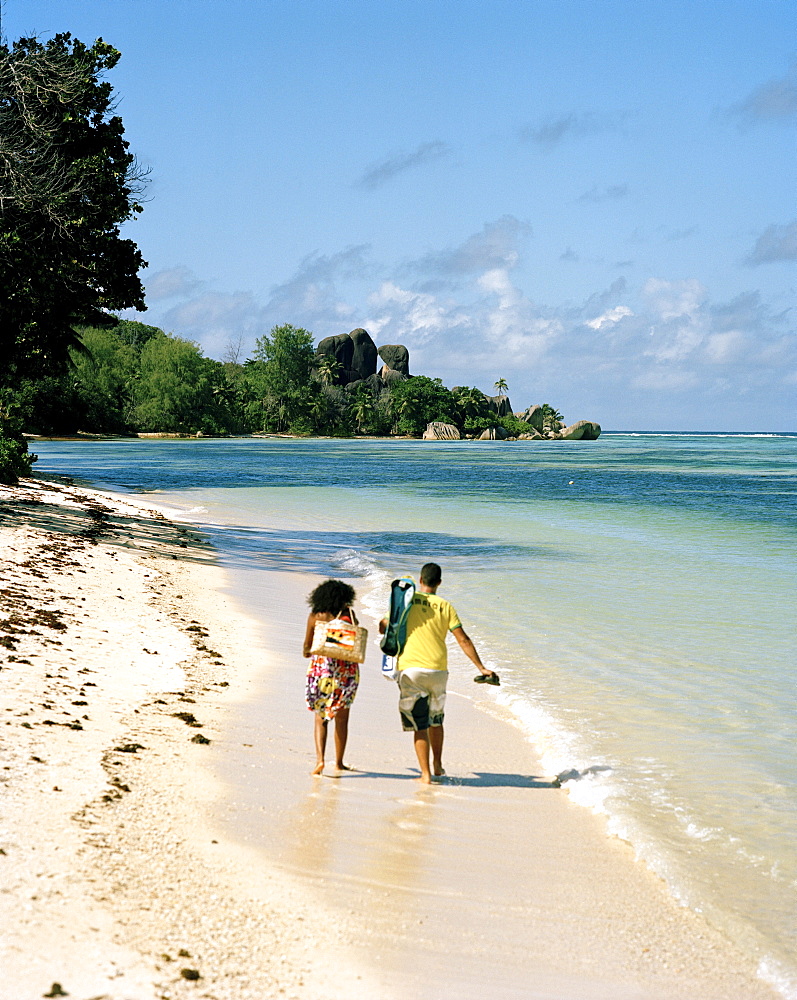 Tourists at L'Union Estate beach, in the background Anse Source d'Argent beach with its granitic rocks, south western La Digue, La Digue and Inner Islands, Republic of Seychelles, Indian Ocean