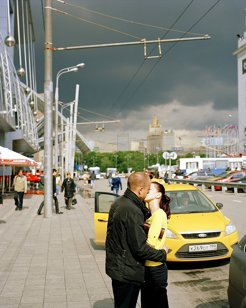 Kissing couple in front of a taxi at Jevropeski Plaza, Moscow, Russia, Europe