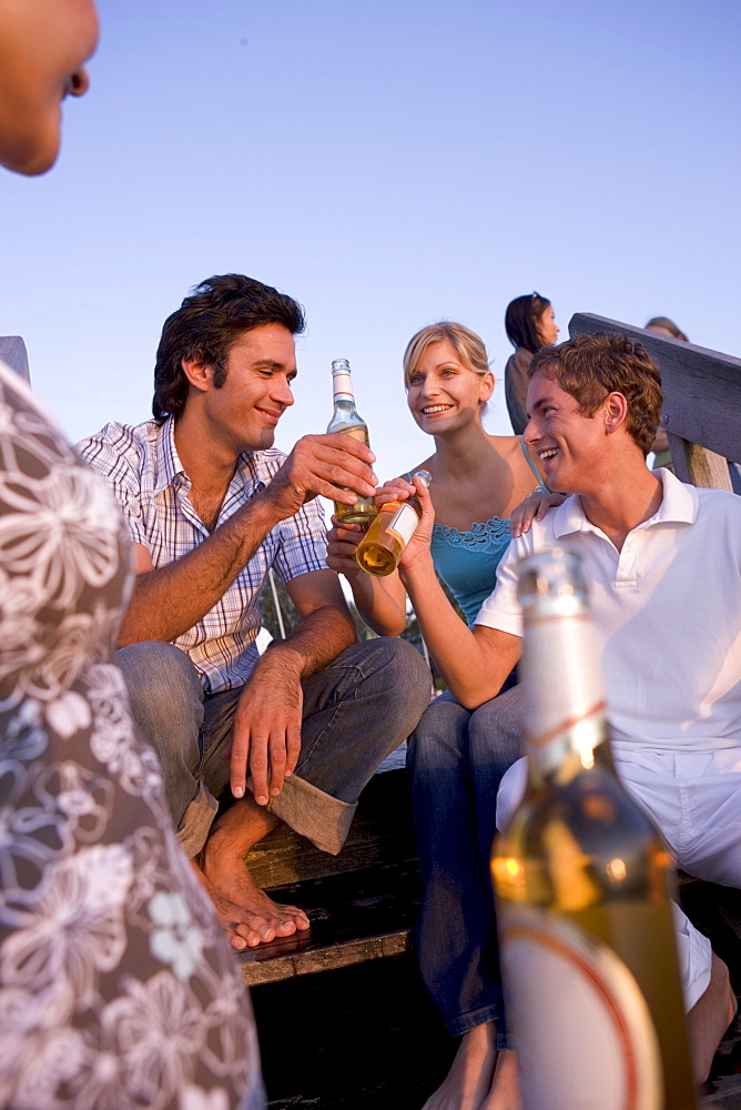 Friends partying on jetty, Lake Starnberg, Bavaria, Germany