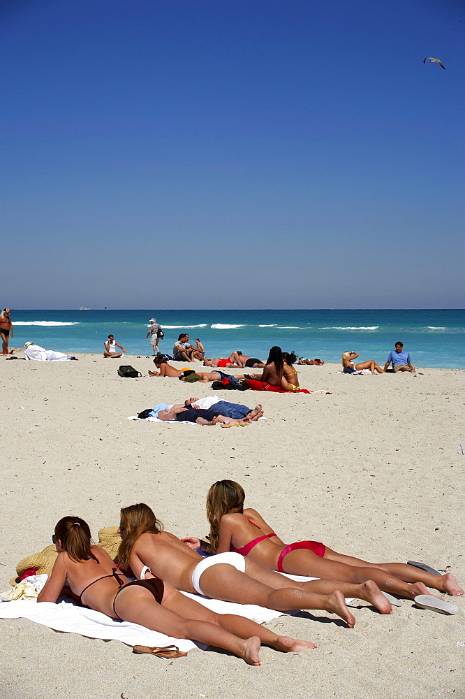 Three young women lying in the sun, beach life, Art Deco Historic Destric, South Beach, Miami, Florida, USA