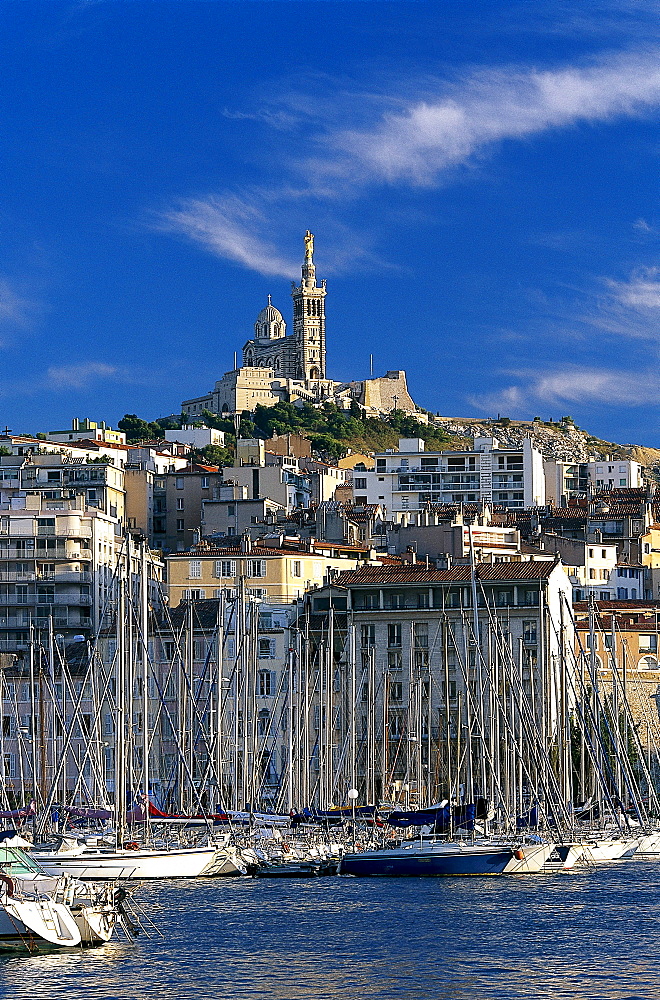 Sailing boats at harbour and the church Notre-Dame-de-la-Garde under clouded sky, Vieux Port, Marseille, Bouches-du-Rhone, Provence, France, Europe