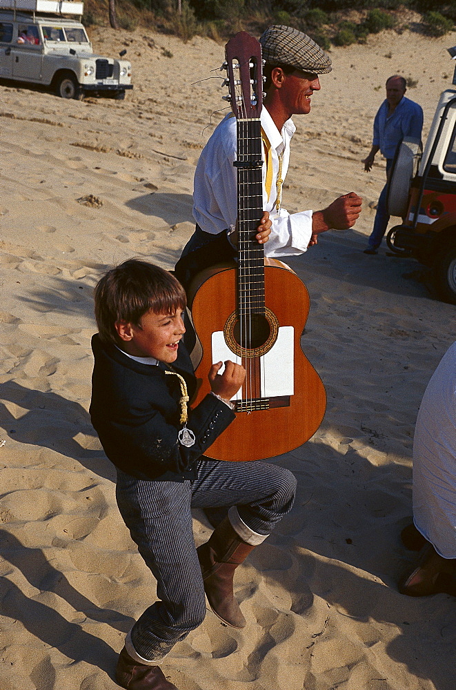 Pilgrim and boy with guitar at national park Donana, El RocÃŒo, Andalusia, Spain, Europe