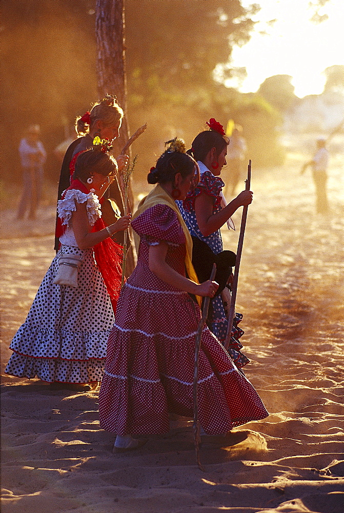 Pilgrims walking with hiking stick along a sandy road, Andalusia, Spain