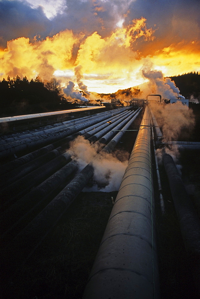 Wairakei Geothermal Power Station, Pipelines and steam at sunset, near Taupo, North Island, New Zealand