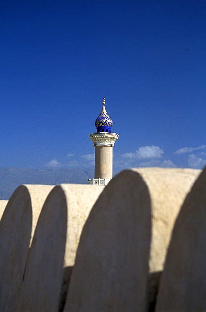 Fort and minaret under blue sky, Nizwa, Oman, Middle East, Asia