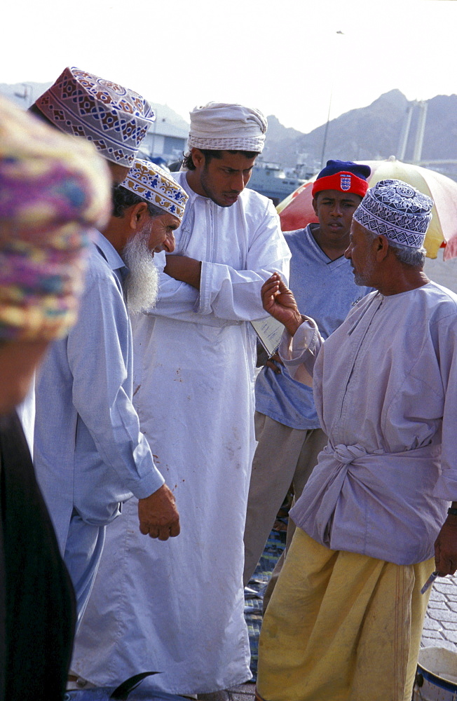 Men discussing at the harbour, Muscat, Oman, Middle East, Asia