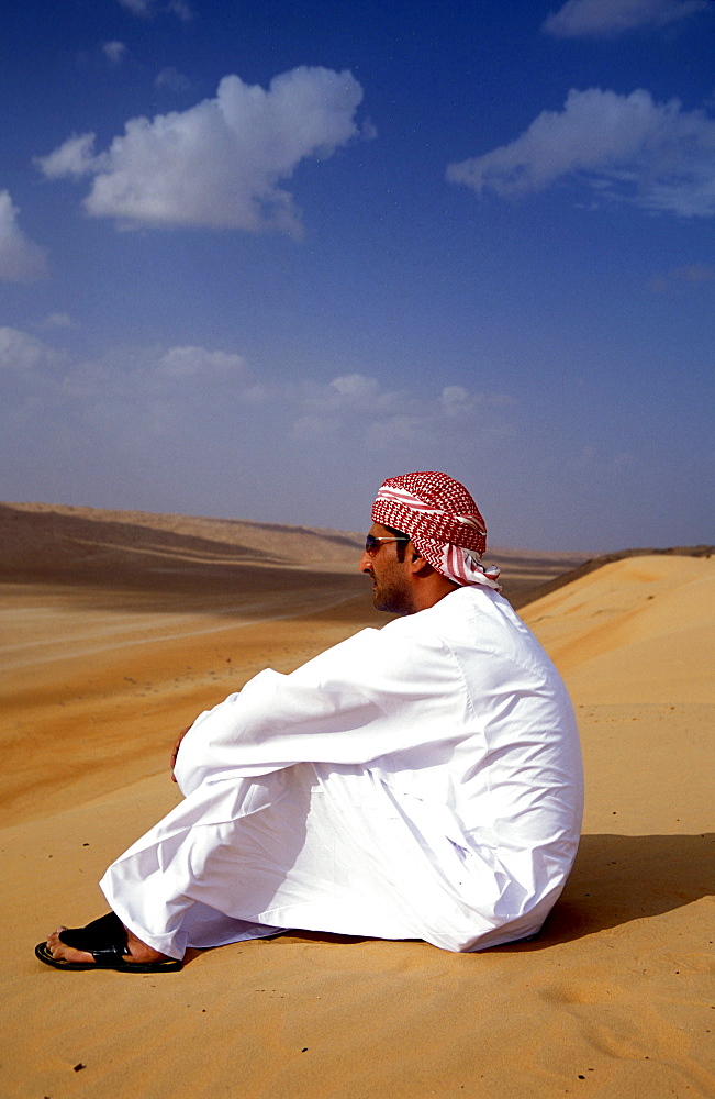 Man sitting in the sand at the desert, Sultanat Oman, Middle East, Asia