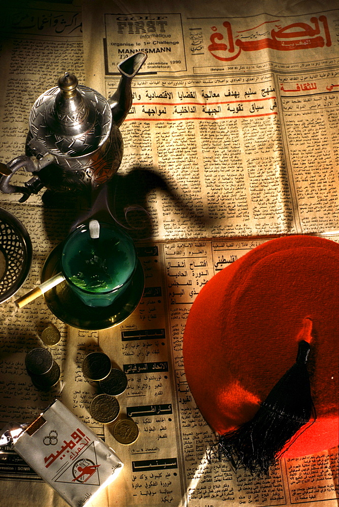 Newspaper, peppermint tea and cigarettes on the table at a teahouse, Fes, Morocco, Africa