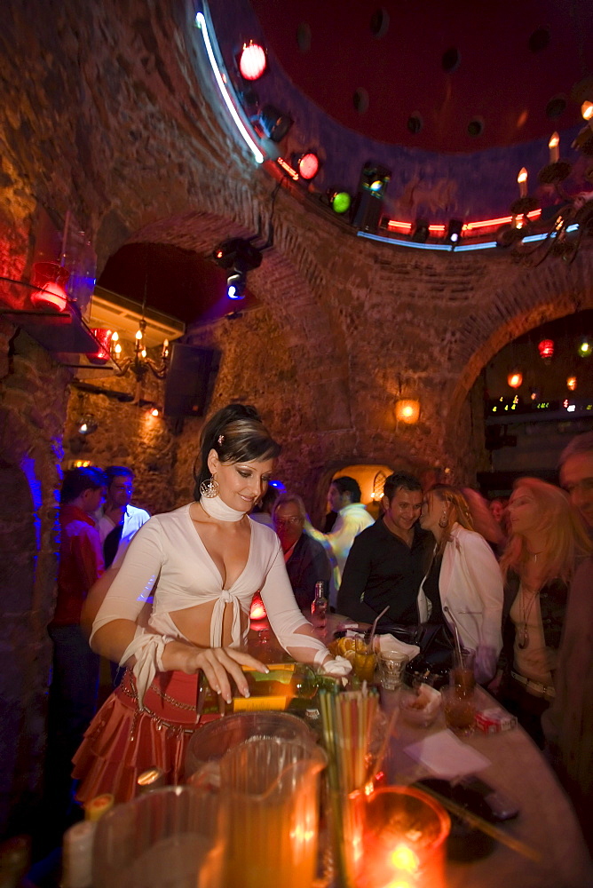 Young woman preparing drinks in the nightclub Hamam Club, Kos-Town, Kos, Greece