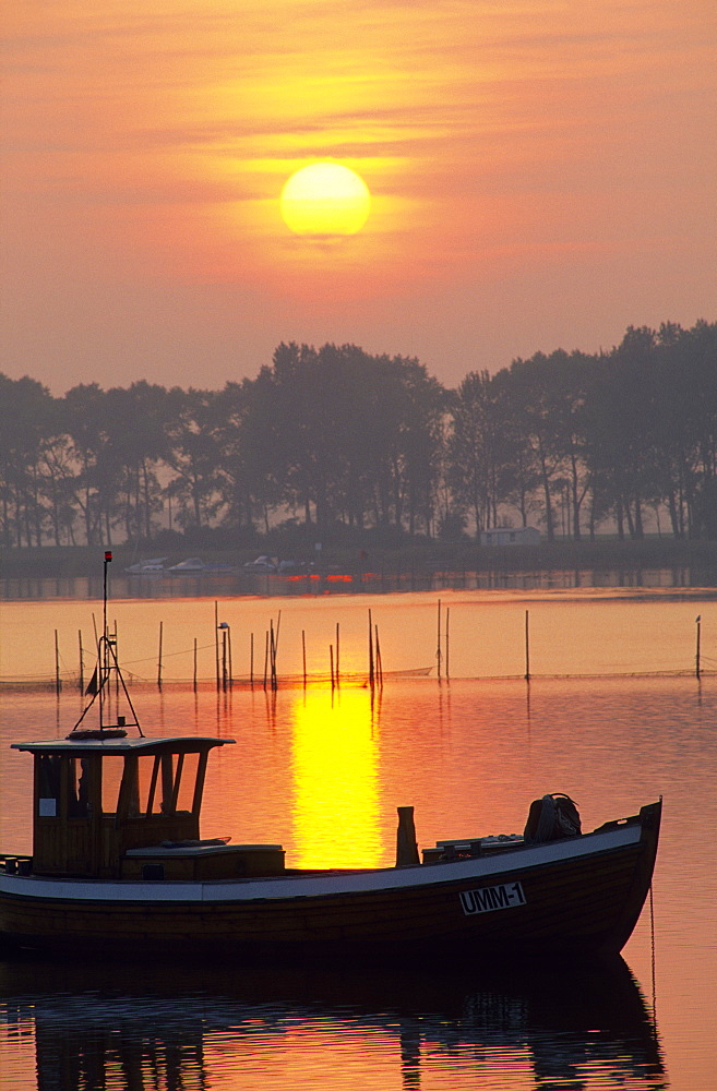 Europe, Germany, Mecklenburg-Western Pomerania, isle of Ruegen, Waase on Ummanz, fishing boat at sunset.