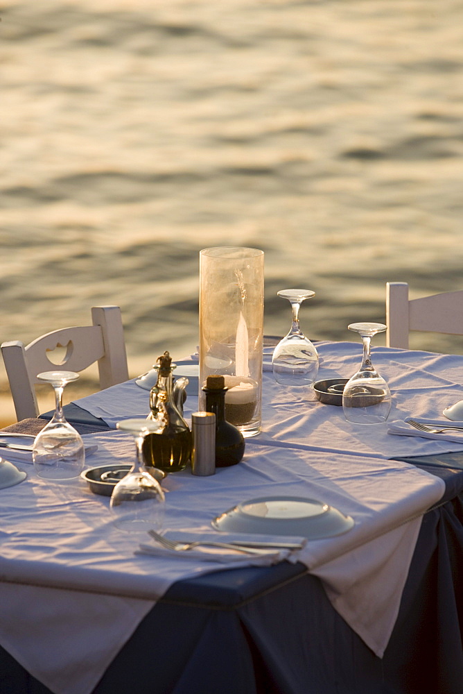 Table with glasses and plates at bank, Little Venice, Mykonos-Town, Mykonos, Greece