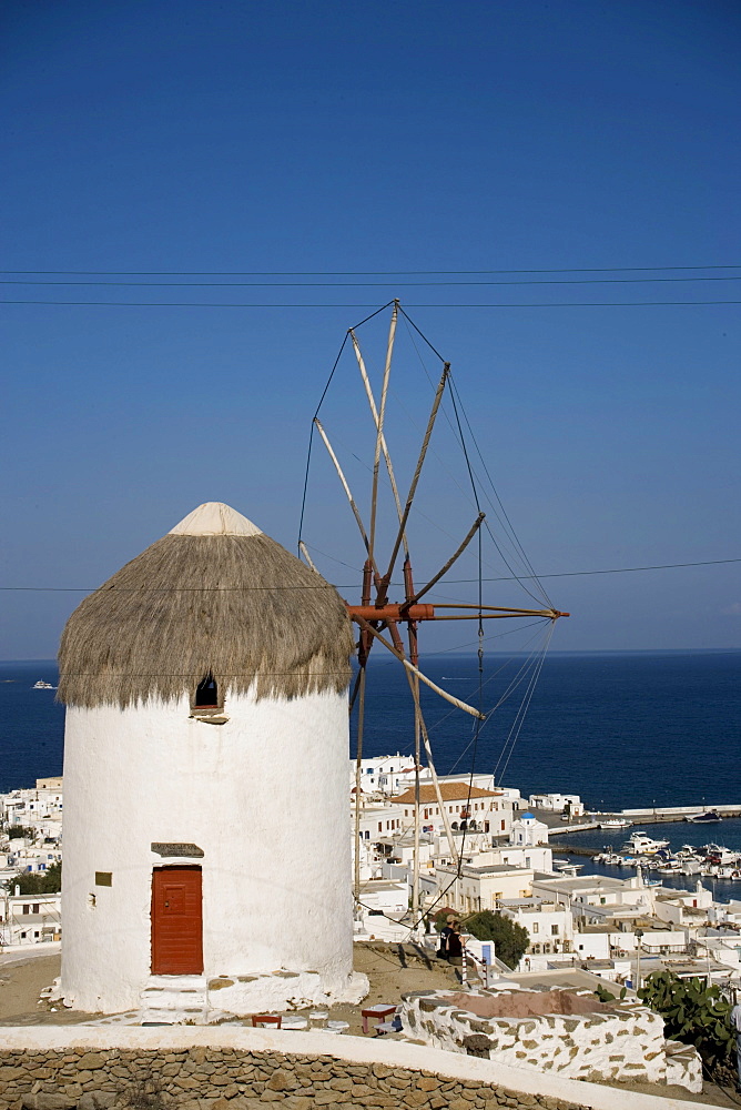 View from hill with famous traditional windmill over the town to the sea with ships, Mykonos-Town, Mykonos, Greece