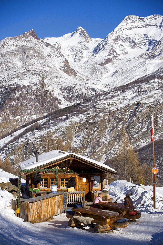 People sitting in front of Fondue Hut of the restaurant Hohnegg, Saas-Fee, Valais, Switzerland