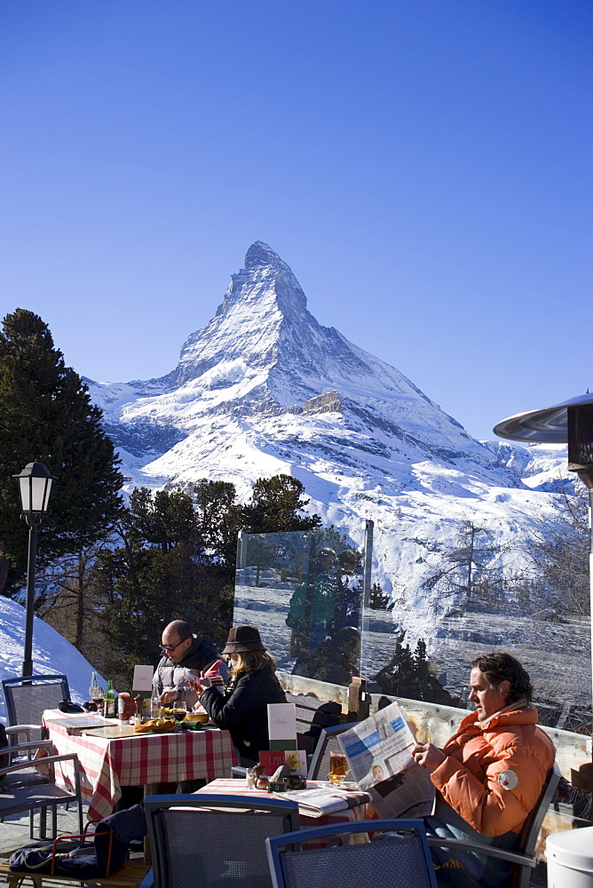 People relaxing on terrace of Hotel and Restaurnat Riffelberg (2582 m), Matterhorn (4478 m) in background, Zermatt, Valais, Switzerland