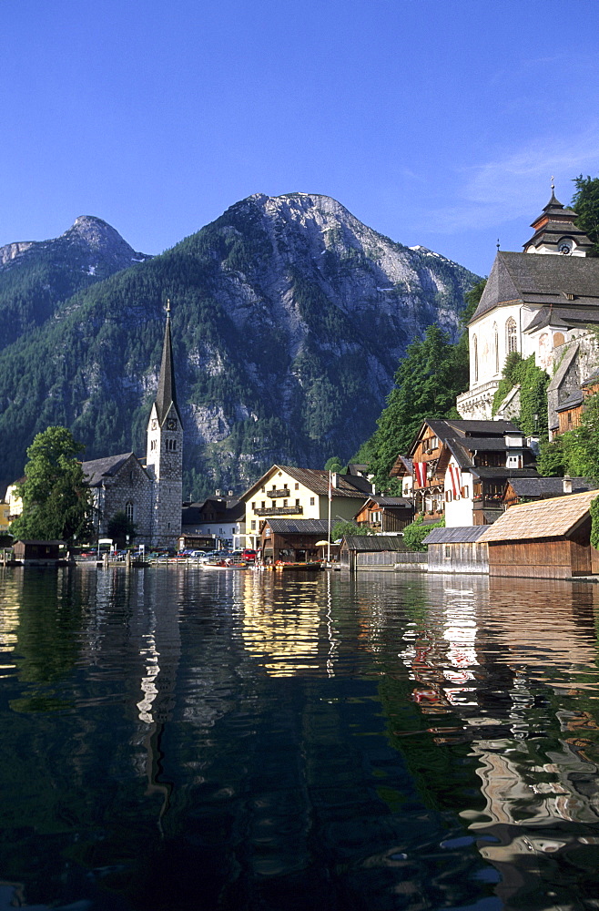 Hallstatt with evangelist and catholic church and reflections in lake Hallstaetter See, Salzkammergut, Upper Austria, Austria