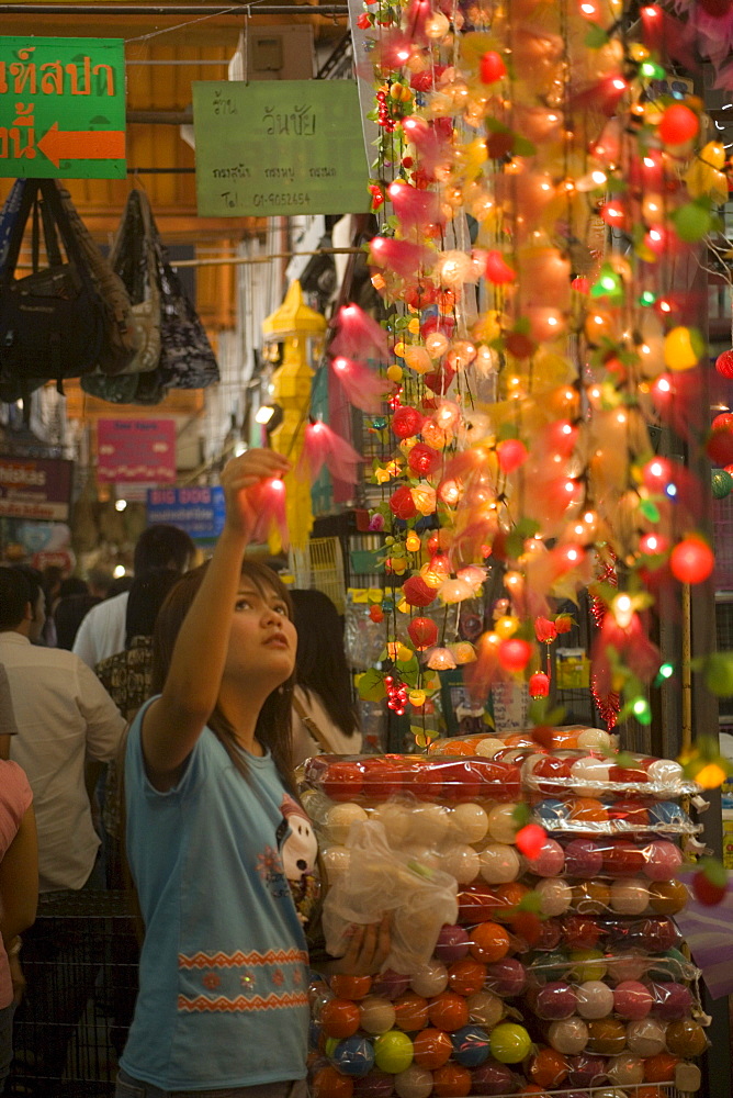 Young woman choosing a fairy lights at Suan Chatuchak Weekend Market, Bangkok, Thailand