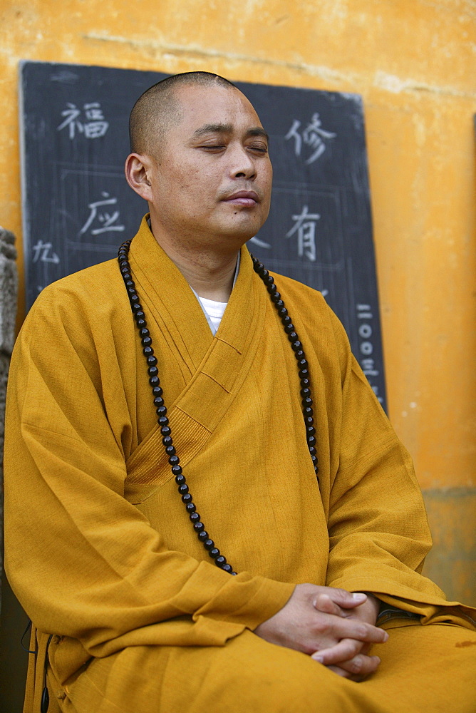 Praying monk at Avalokiteshvara monastery, Jiuhua Shan, Anhui province, China, Asia