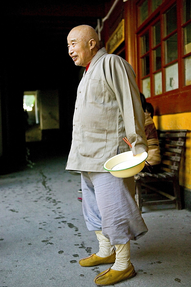 Smiling monk holding rice bowl, Putuo Shan, Zhejiang Province, China, Asia